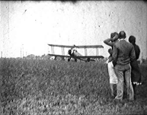 archive footage still of bi-plane in a field